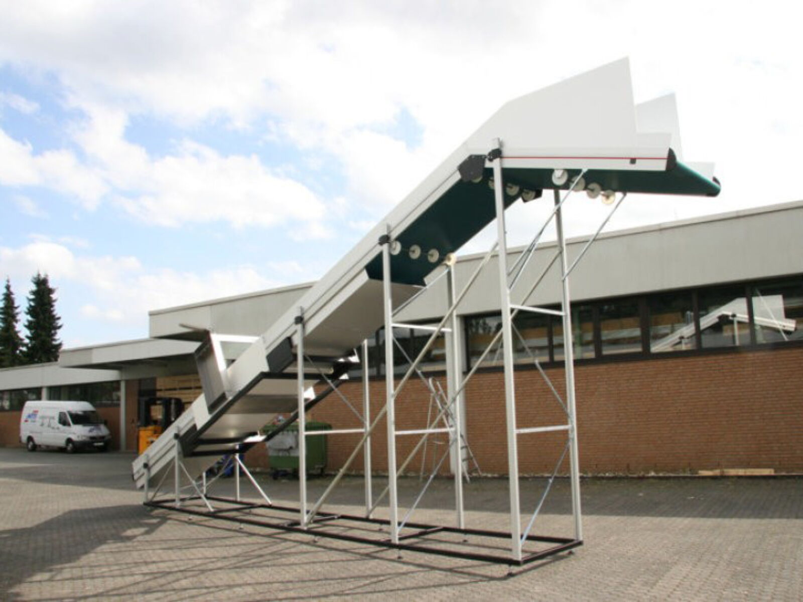 Positiv abgewinkeltes, hohes Zuführförderband mit Metalldetektor für die sichere Förderung von Kunststoffteilen in Schneidmühle